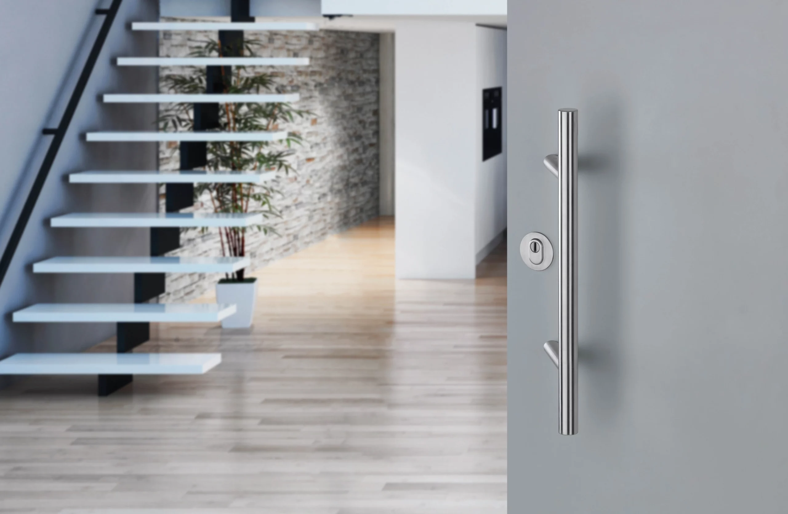 Langer Edelstahl-Türgriff an Haustür, moderner Eingangsbereich.Longue poignée en inox sur porte d’entrée, hall moderne.