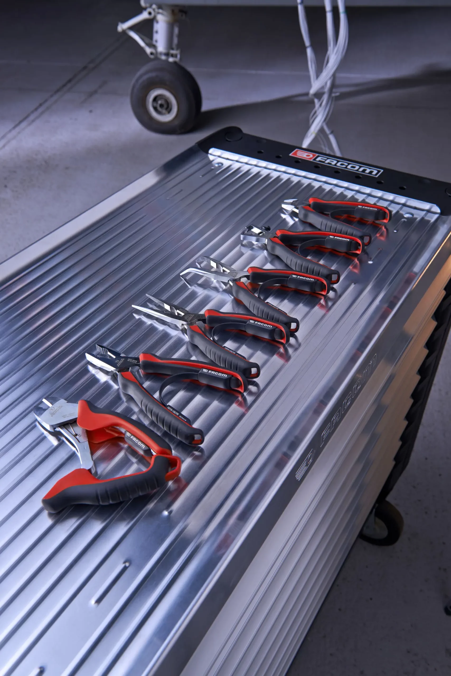 Zangen mit rotem Griff auf Facom-Werkbank. Pinces à poignée rouge sur établi Facom.